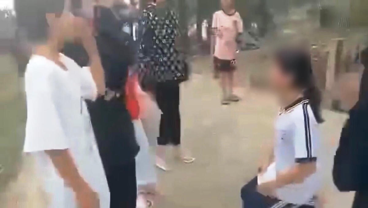 Nhóm học sinh bắt Q. quỳ xuống. (Ảnh cắt clip).