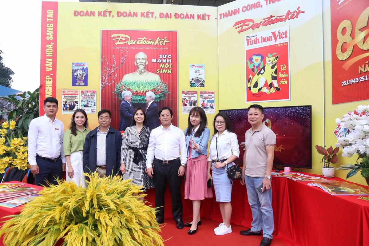 Cán bộ, phóng viên Báo Đại Đoàn Kết chụp ảnh lưu niệm bên gian trưng bày báo của Báo Đại Đoàn Kết.