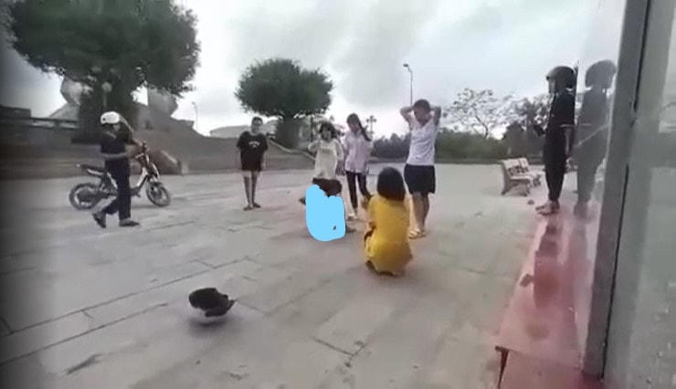 Nữ sinh bị hai bạn nữ khác đánh và lột áo quần. Ảnh cắt từ clip.
