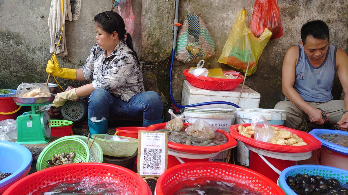 Phương thức thanh toán không dùng tiền mặt - QR code được sử dụng ngày càng nhiều tại chợ dân sinh. Ảnh: H.Nhi.  