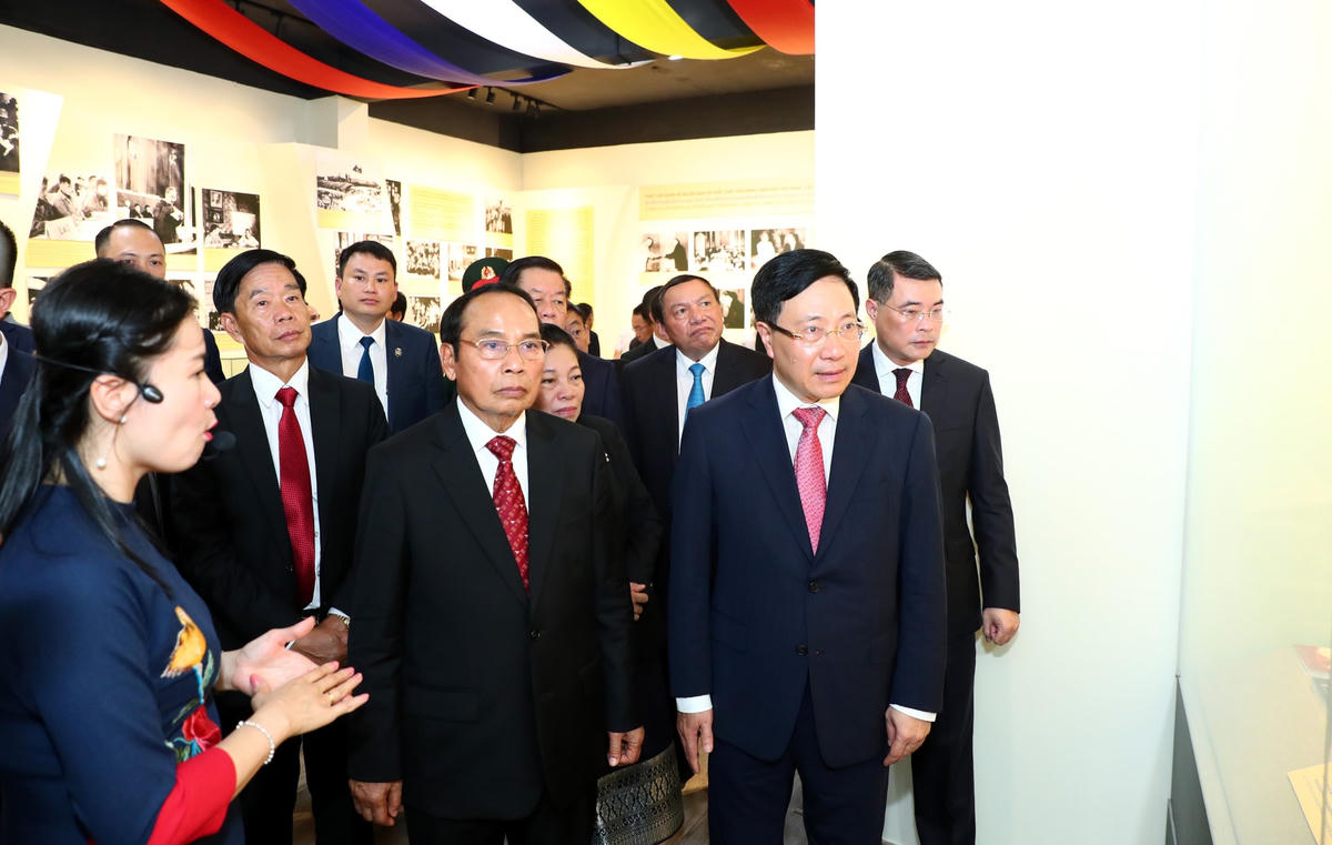 Phó Thủ tướng Thường trực Chính phủ Phạm Bình Minh và Thường trực Ban Bí thư Lào Bounthong Chitmany thăm quan triển lãm. Ảnh: Quang Vinh.