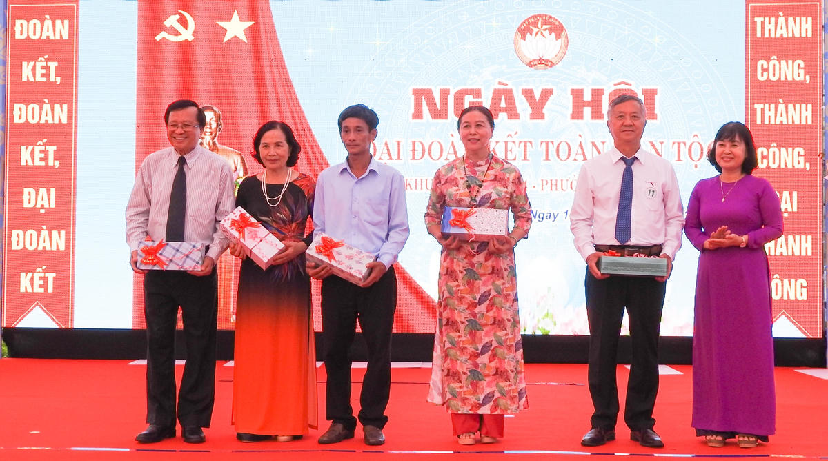  Trưởng Ban Dân vận Quận ủy, Chủ tịch Ủy ban MTTQ Việt Nam quận Cẩm Lệ Phạm Thị Nhàn (phải) trao quà cho các cá nhân tiêu biểu ở khu dân cư. Ảnh: Thanh Tùng.