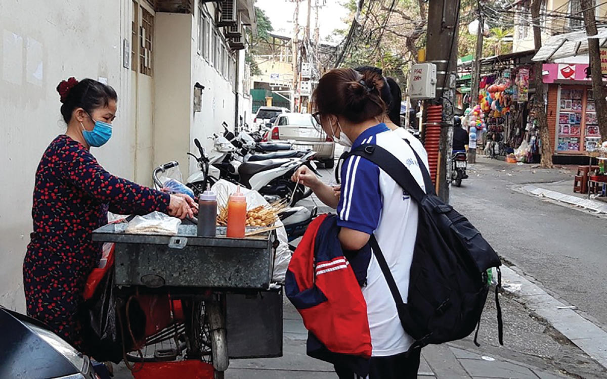Nhiều học sinh, sinh viên “mê” đồ ăn vặt không rõ nguồn gốc ở cổng trường. Ảnh: Ngọc Hà.  
