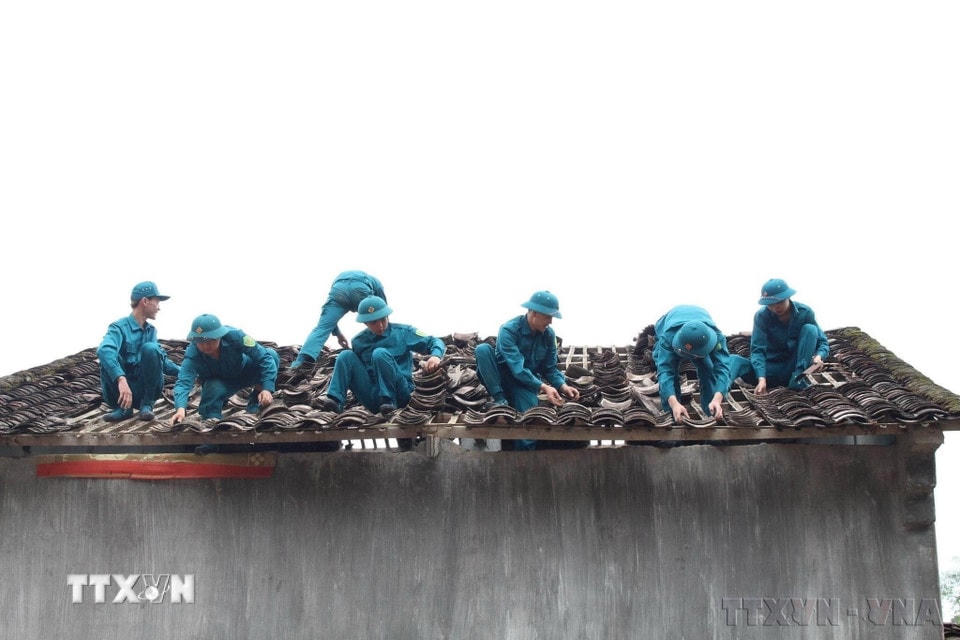 Lực lượng dân quân tự vệ giúp đỡ các gia đình bị thiệt hại lợp lại mái nhà bị hư hỏng do mưa đá tại hai huyện Trùng Khánh, Quảng Hòa và Hà Quảng, tỉnh Cao Bằng, tháng 5/2023. (Ảnh: TTXVN)
