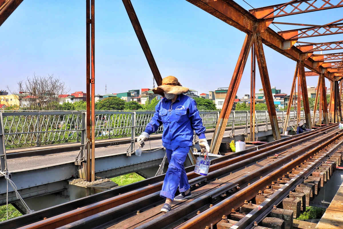 Có mặt trên cầu, PV bắt gặp những công nhân đường sắt vẫn miệt mài kiểm tra, sơn sửa các vị trí bị hư hỏng tại cầu Long Biên dưới tiết trời "như thiêu như đốt".