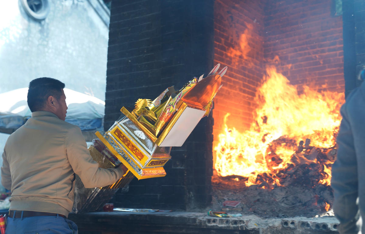 Ngoài ngựa giấy, những lễ vật khác cũng được thay nhau cho vào lò hoá vàng mã.