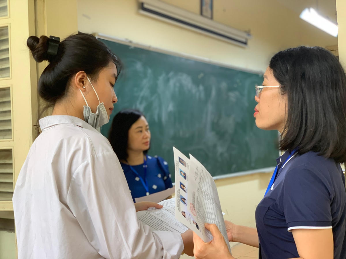 Cán bộ coi thi kiểm tra thông tin thí sinh trước khi vào phòng thi tốt nghiệp THPT 2023.
