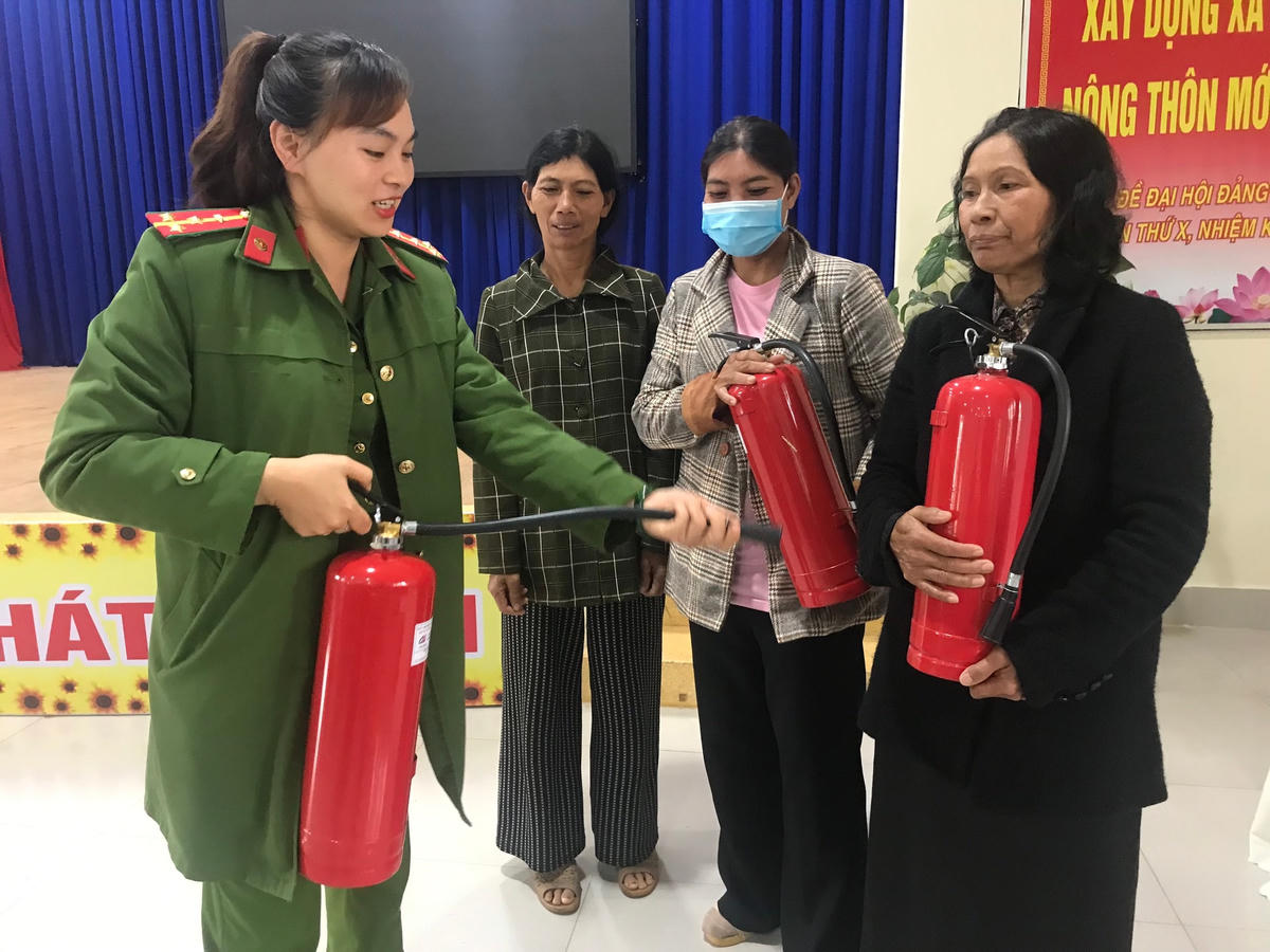 Cán bộ phòng PC07 hướng dẫn cách sử dụng bình chữa cháy xách tay cho các hộ đồng bào dân tộc thiểu số.