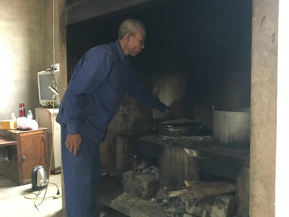 Ông Hồng tranh thủ nấu cám lợn giúp vợ.