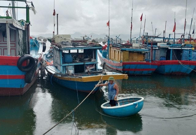 Ngư dân kiểm tra tàu thuyền trước khi bão số 4 đổ bộ vào đất liền. Ảnh: Tấn Thành - Chí Đại.
