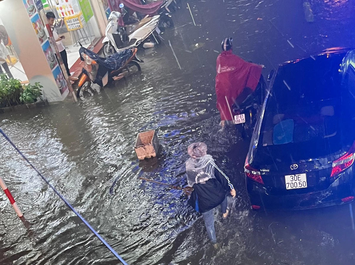 Một đoạn phố Mai Dịch (quận Cầu Giấy) nước ngập nửa bánh xe. Ảnh: Thái Nhung.