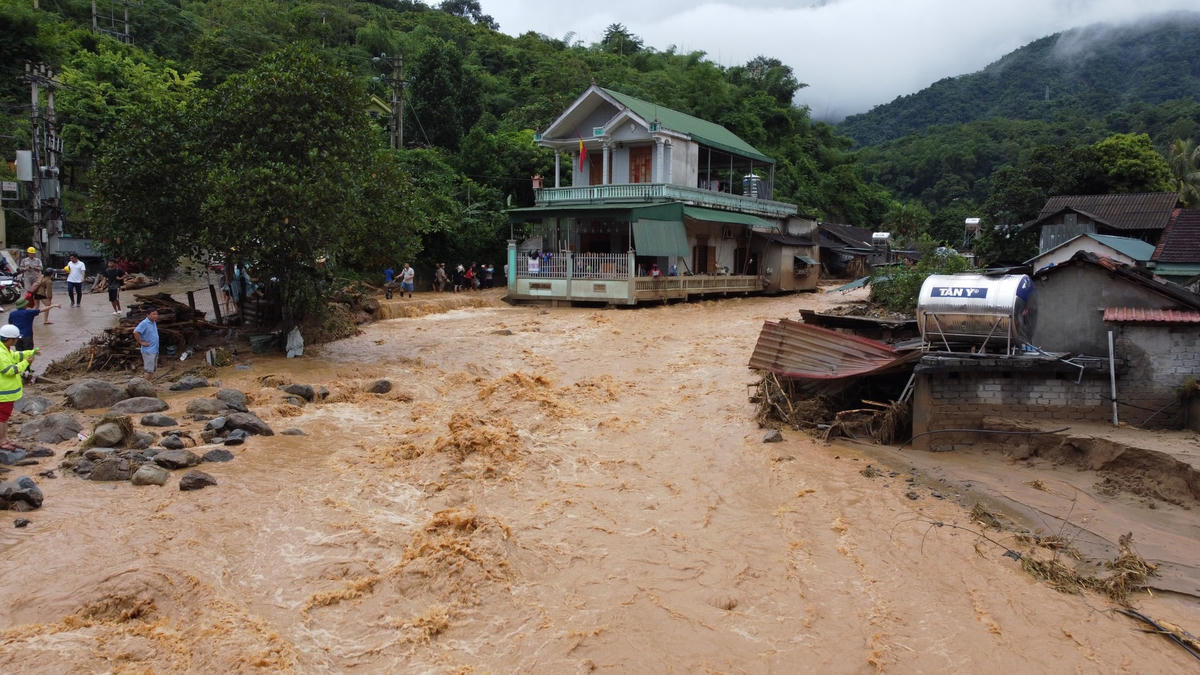 Cơn lũ đâm thẳng vào các nhà dân, khiến nhiều tài sản đã bị cuốn trôi. Ảnh Điền Bắc.