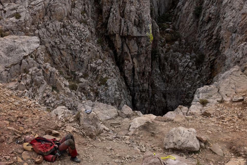 Một nhân viên cứu hộ nghỉ ngơi ở lối vào Hang Morca. Ảnh: Reuters.