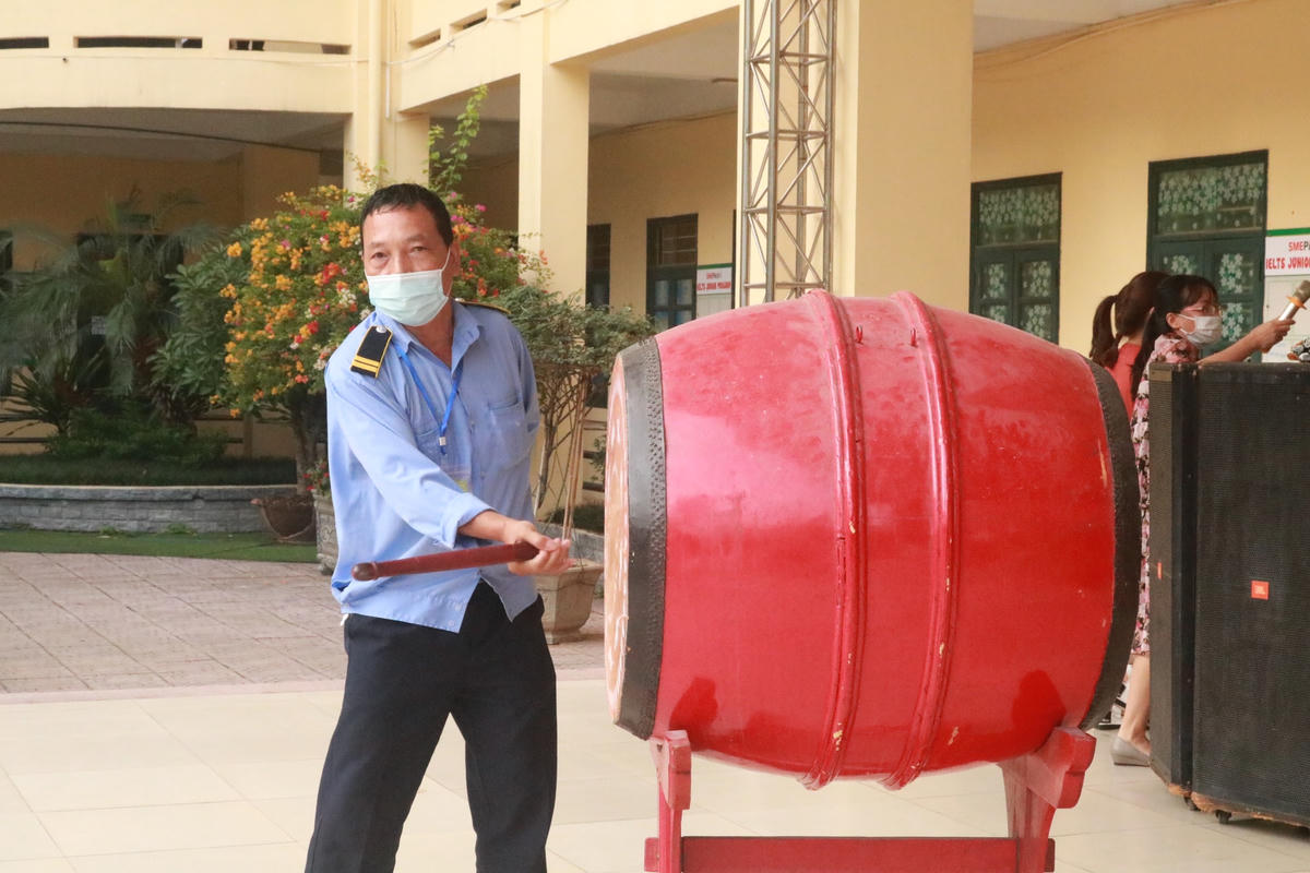 Bảo vệ tại điểm thi Trường THPT Phan Huy Chú đánh trống báo hiệu thí sinh vào phòng thi.