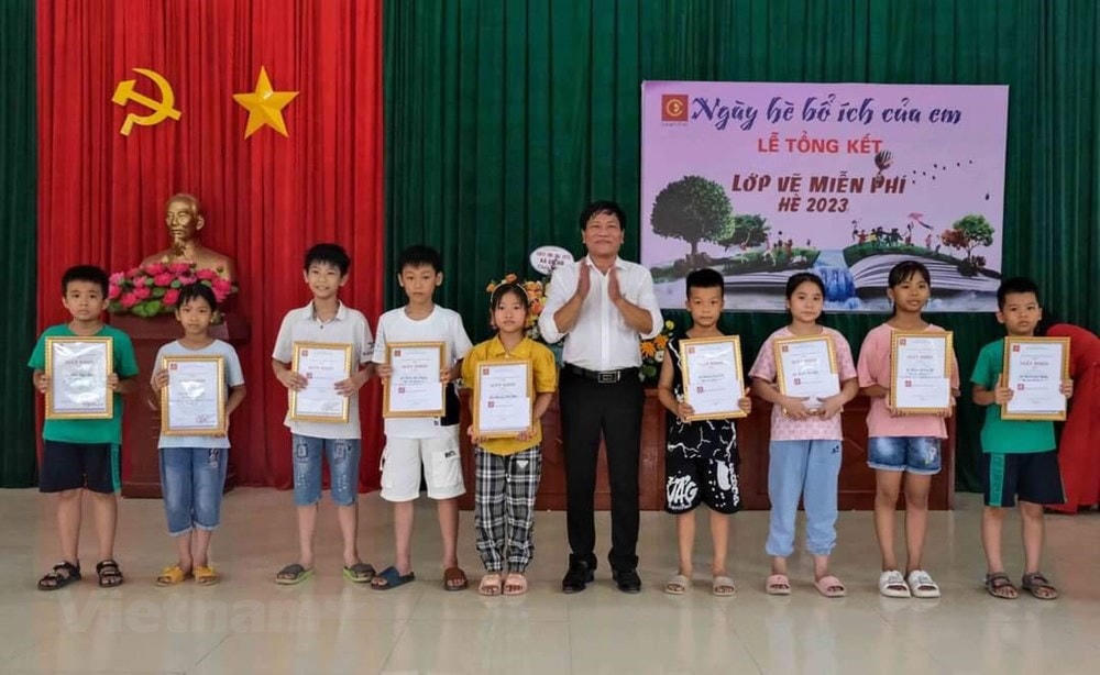 Họa sĩ Hoàng Tuấn Việt, Chủ nhiệm Câu lạc bộ Mỹ thuật Cổ Đô trao giấy khen cho những học sinh hoàn thành xuất sắc khóa học. (Nguồn: Vietnam+).