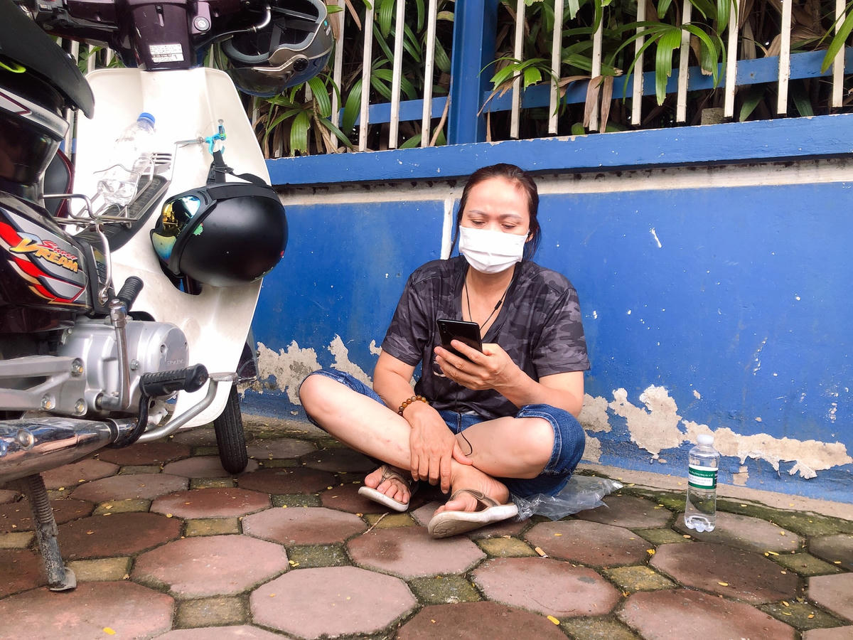 Còn vị phụ huynh này ngồi bệt một góc vỉa hè cho đỡ mỏi chân.
