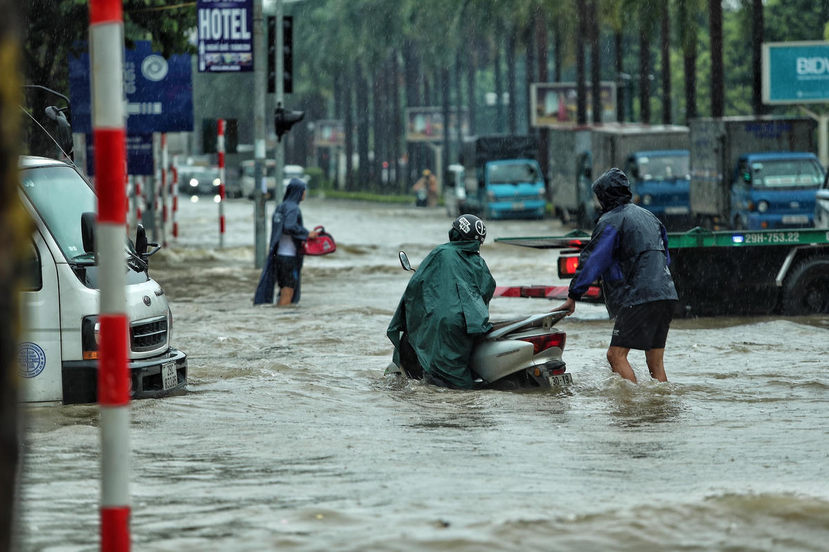 Nhiều người dân phụ giúp đưa các xe bị chết máy lên một vị trí cao hơn.