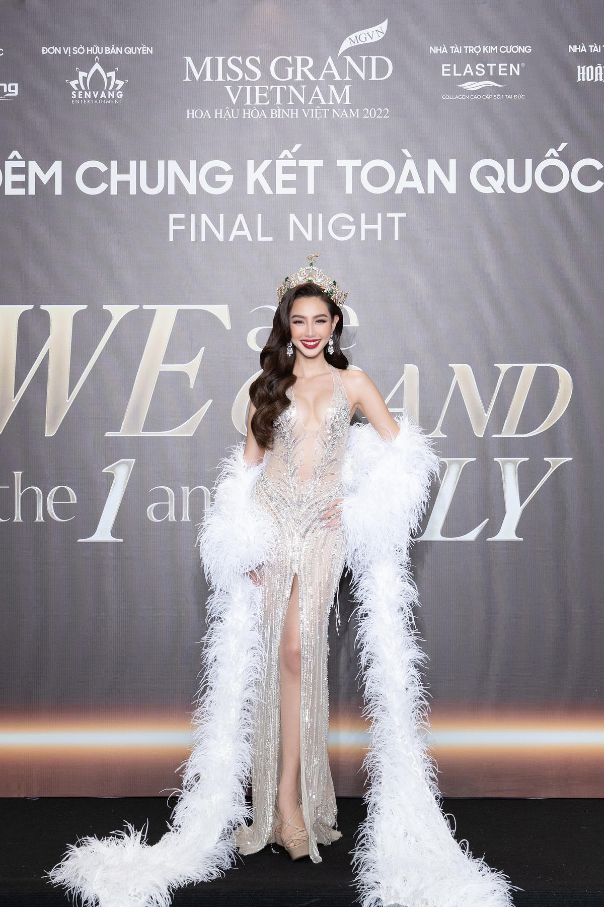 Hoa hậu Thùy Tiên đội vương miện, xuất hiện rạng rỡ trên thảm đỏ. Thiết kế váy xẻ sâu giúp người đẹp sinh năm 1998 khoe trọn body săn chắc. 