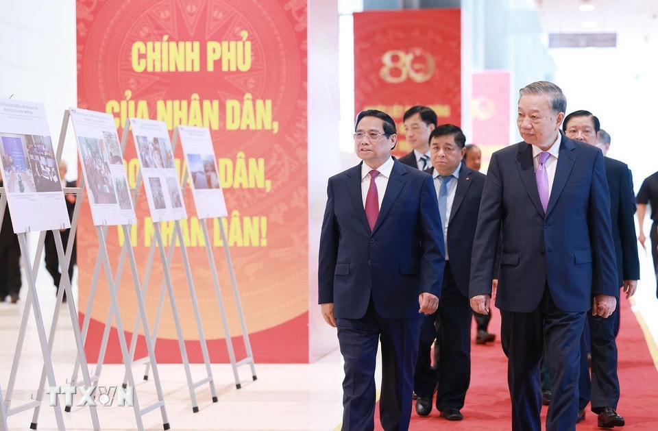 Tổng Bí thư Tô Lâm và Thủ tướng Phạm Minh Chính cùng các đại biểu tham quan trưng bày ảnh về hoạt động của Chính phủ qua các thời kỳ do TTXVN thực hiện. (Ảnh: Dương Giang/TTXVN)