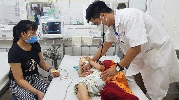 Bệnh nhi mắc bệnh tay chân miệng được bác sĩ Bệnh viện Phụ sản - Nhi Đà Nẵng khám. Ảnh: TTXVN.
