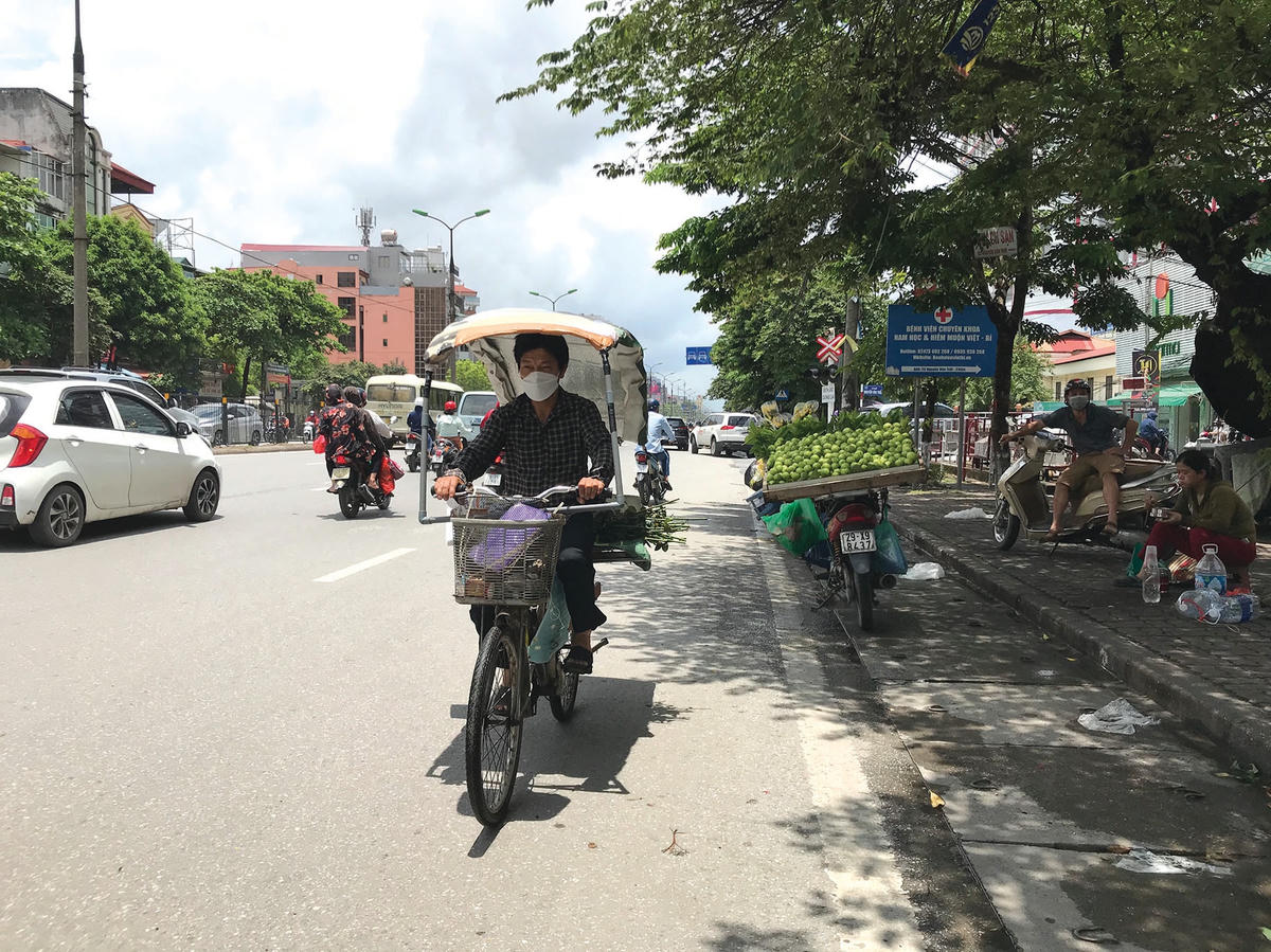 Một người đàn ông tự chế cho chiếc xe đạp của mình một “chiếc ô” che bớt nắng.  