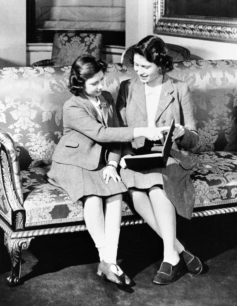 Công chúa Elizabeth (phải) và Công chúa Margaret Rose (bên trái) cùng đọc sách tại Cung điện Buckingham .