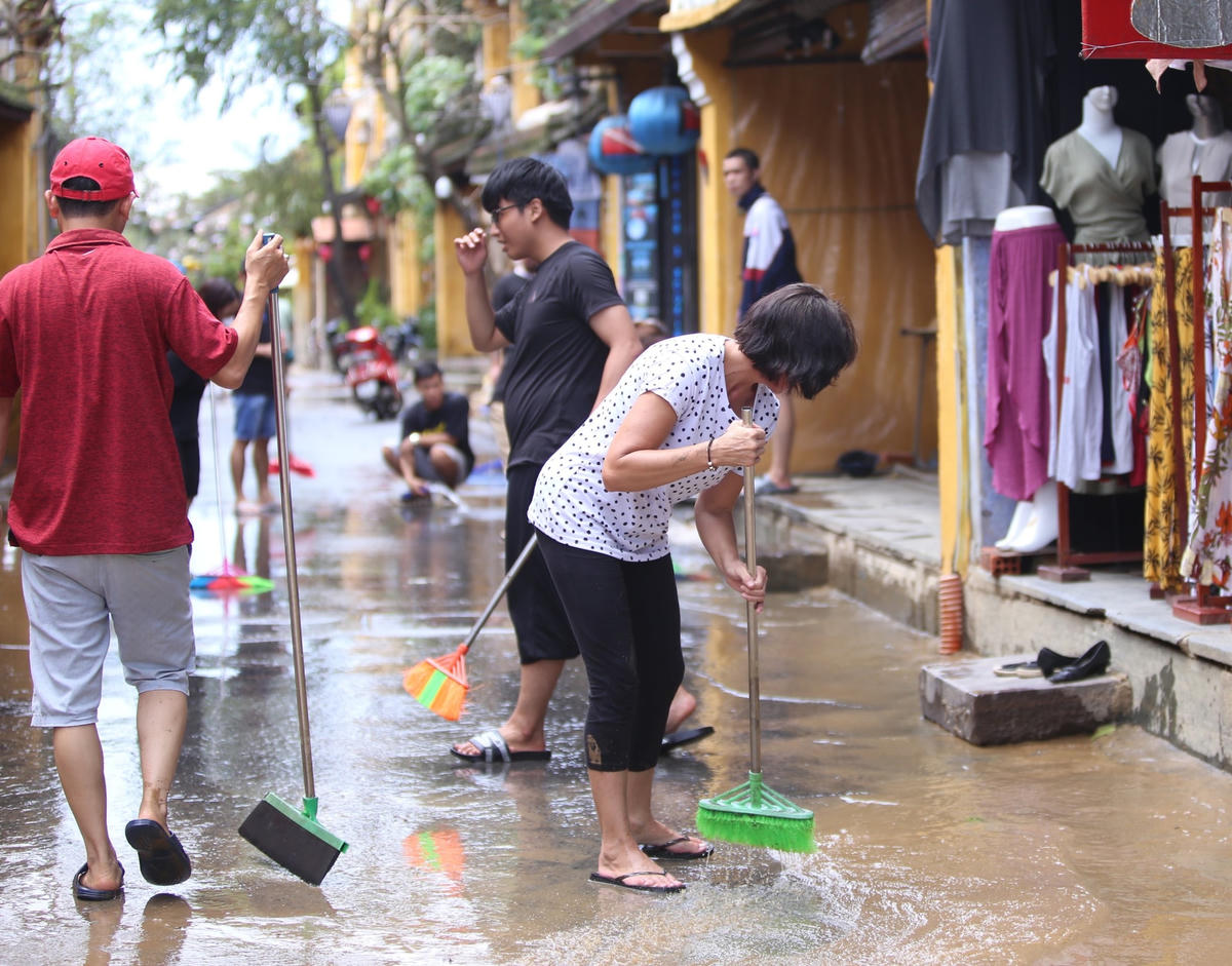 Người dân TP Hội An dọn bùn đất trên đường.