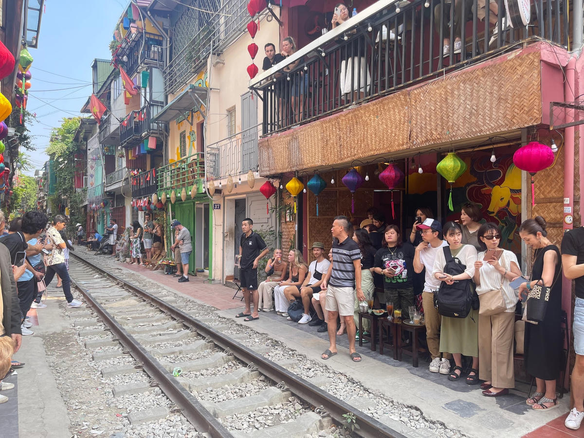 Khoảng 11h45, tàu bắt đầu chay qua, khi đó các chủ quán sẽ yêu cầu du khách mới đứng sát vào lề đường.