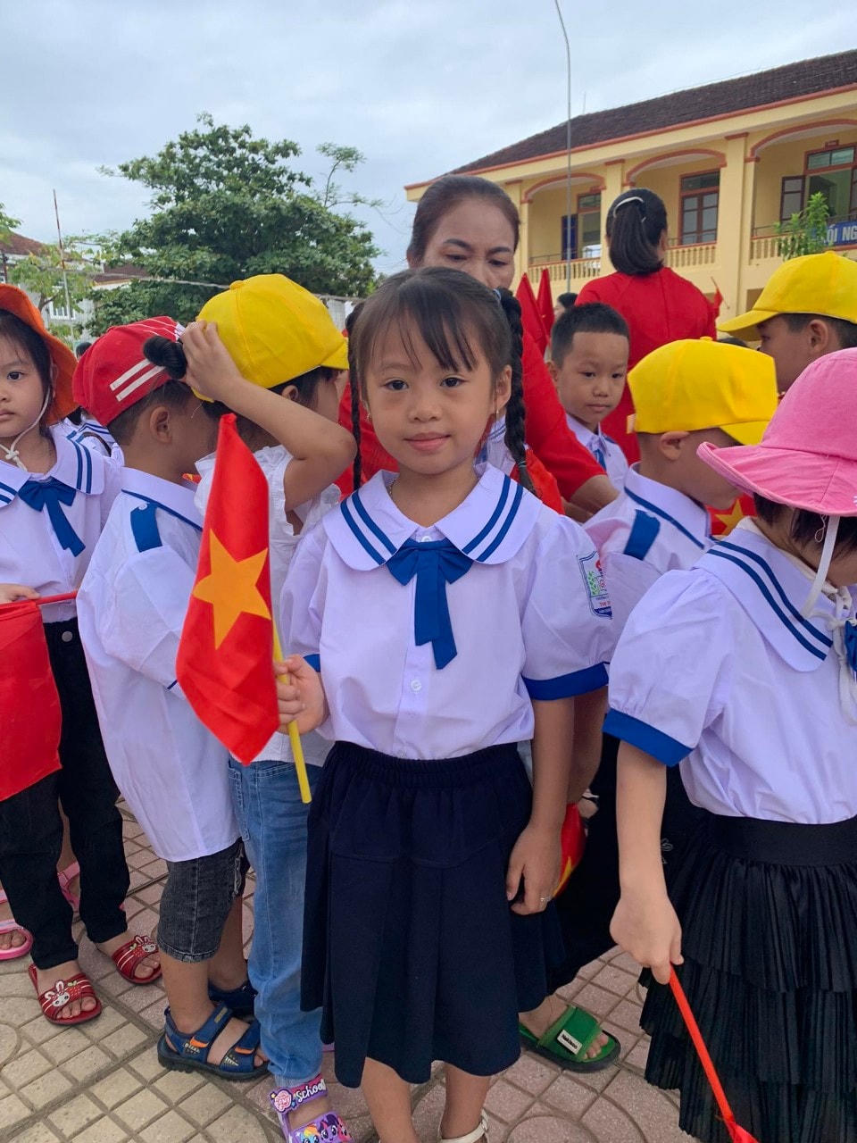 Cháu Hà Nhiên, học sinh Lớp 1D Trường Tiểu học thị trấn Thanh Chương được bố mẹ chở đến trường từ sáng sớm, với niềm hân hoan chào đón năm học mới. Ảnh Lê Hường.