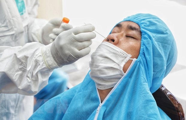 Nhân viên y tế lấy mẫu xét nghiệm Covid-19 cho người dân. Ảnh: TTXVN.