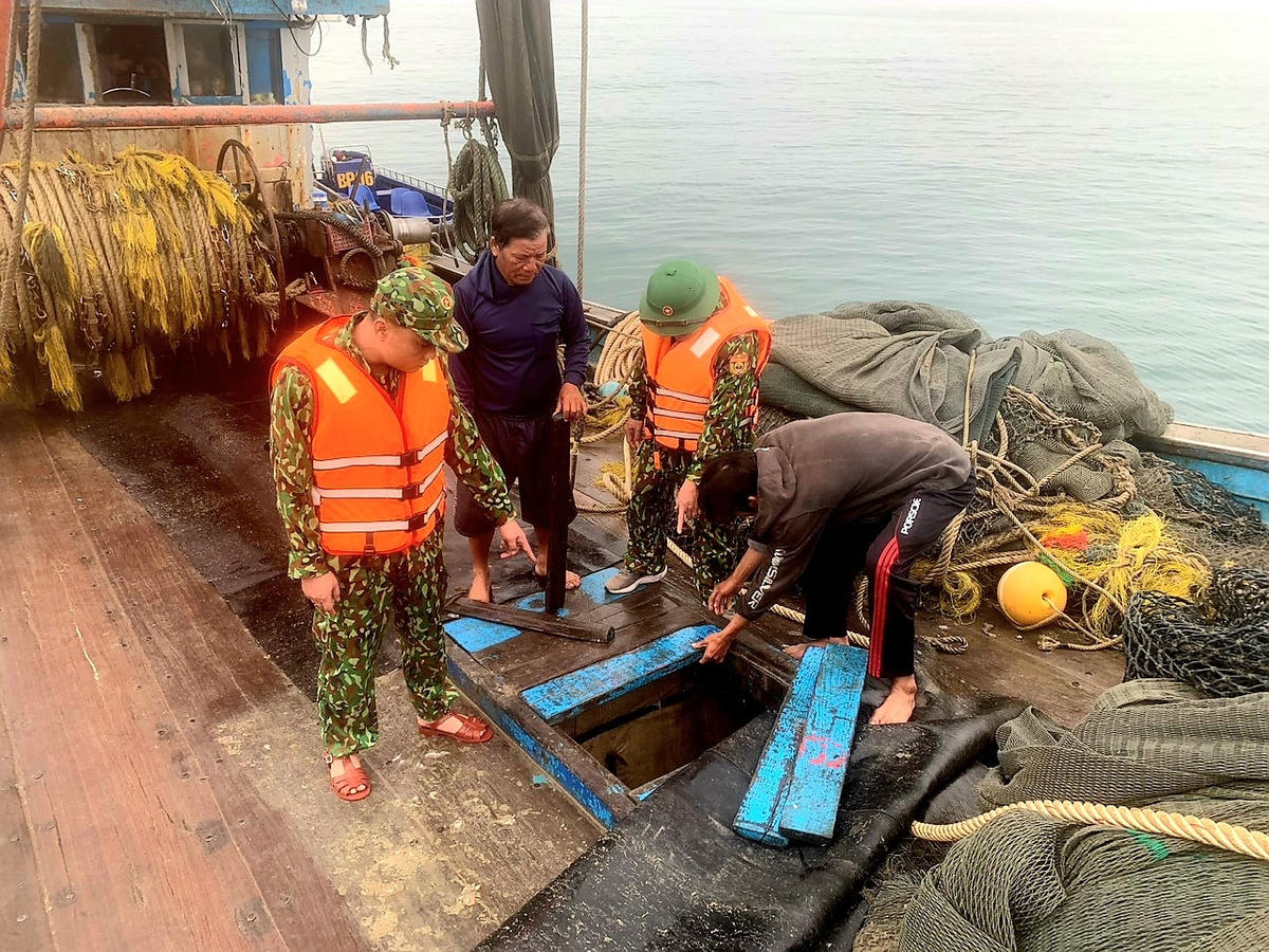 Lực lượng chức năng tiến hành kiểm tra tàu cá vi phạm.