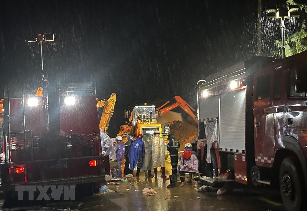 Rạng sáng 31/7, lực lượng chức năng vẫn làm việc để giải tỏa hiện trường vụ sạt lở và tìm kiếm nạn nhân mất tích. (Ảnh: Nguyễn Dũng/TTXVN).