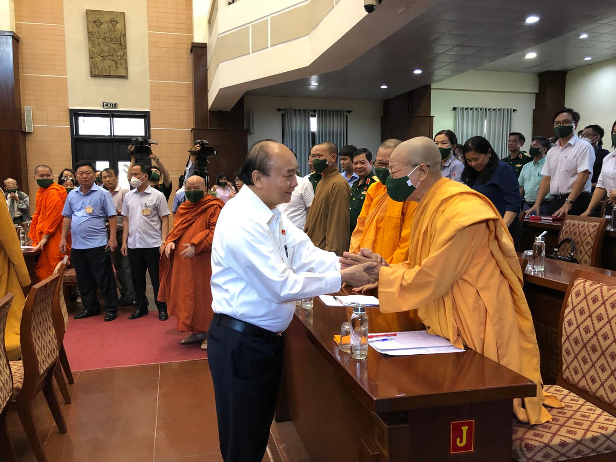 Chủ tịch nước Nguyễn Xuân Phúc thăm hỏi sức khỏe và trao đổi với đại diện cử tri là chức sắc Phật giáo tại buổi tiếp xúc cử tri (Ảnh: Thành Luân).