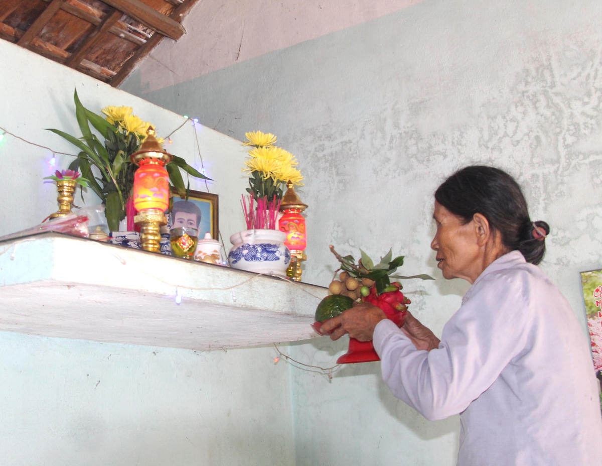 Bà Nguyễn Thị Lâm đặt trái cây lên bàn thờ của cha.