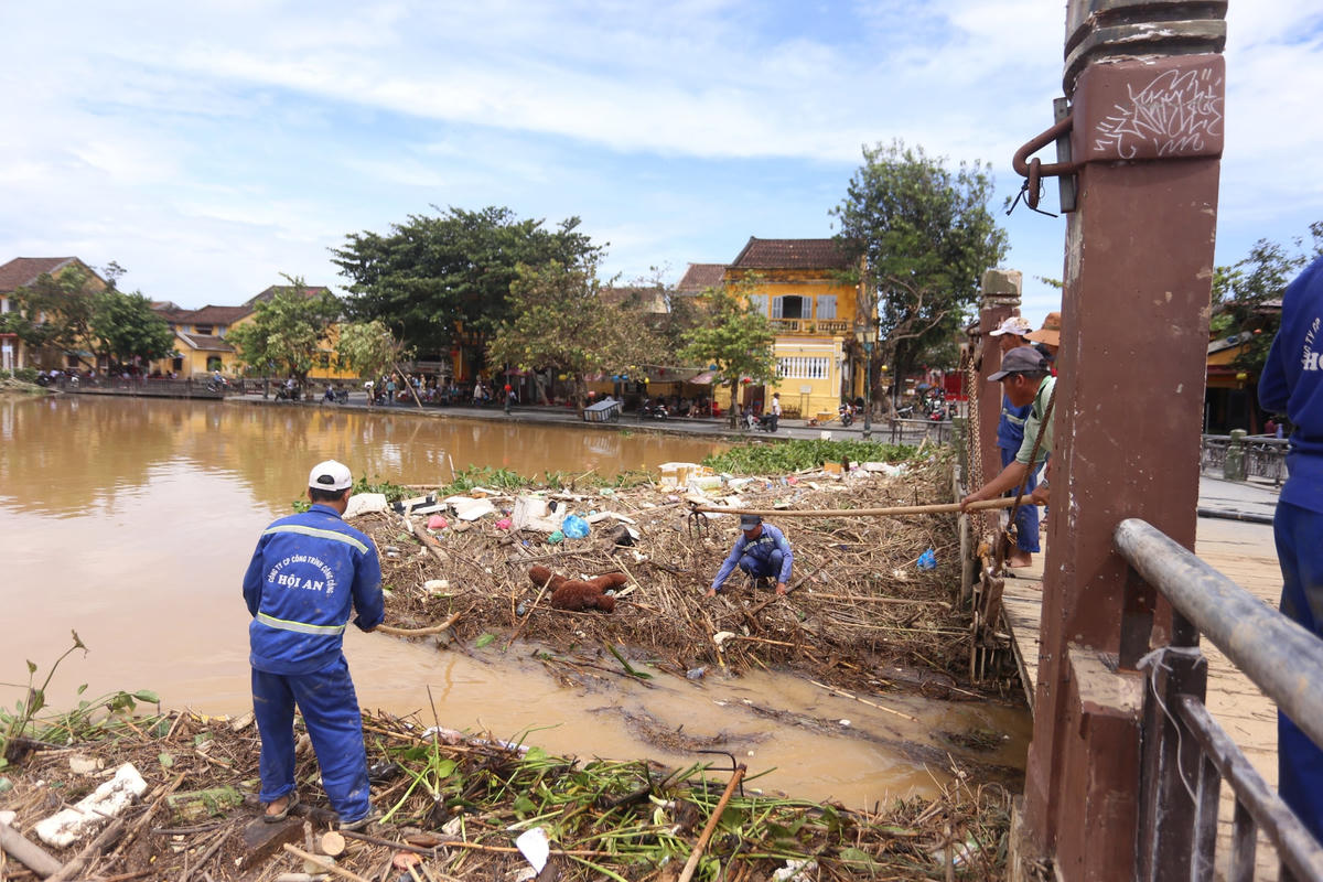 Công nhân dọn rác thải ứ đọng trên sông Hoài.