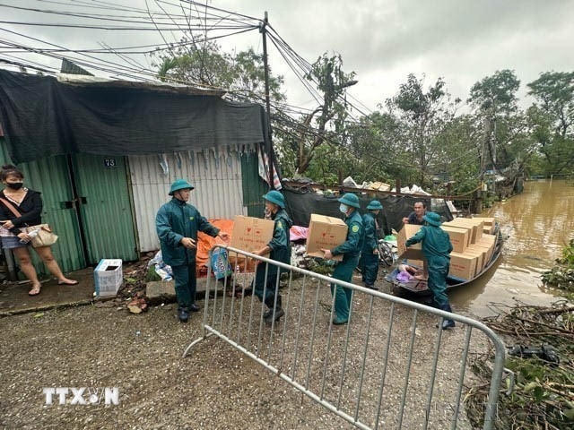 Lực lượng dân quân tự vệ giúp người dân tại các phường trên địa bàn quận Tây Hồ và Ba Đình ven sông Hồng đưa tài sản, vào bờ sơ tán do mực nước sông Hồng dâng cao gậy ngập úng, tháng 9/2024. (Ảnh: Huy Hùng/TTXVN)