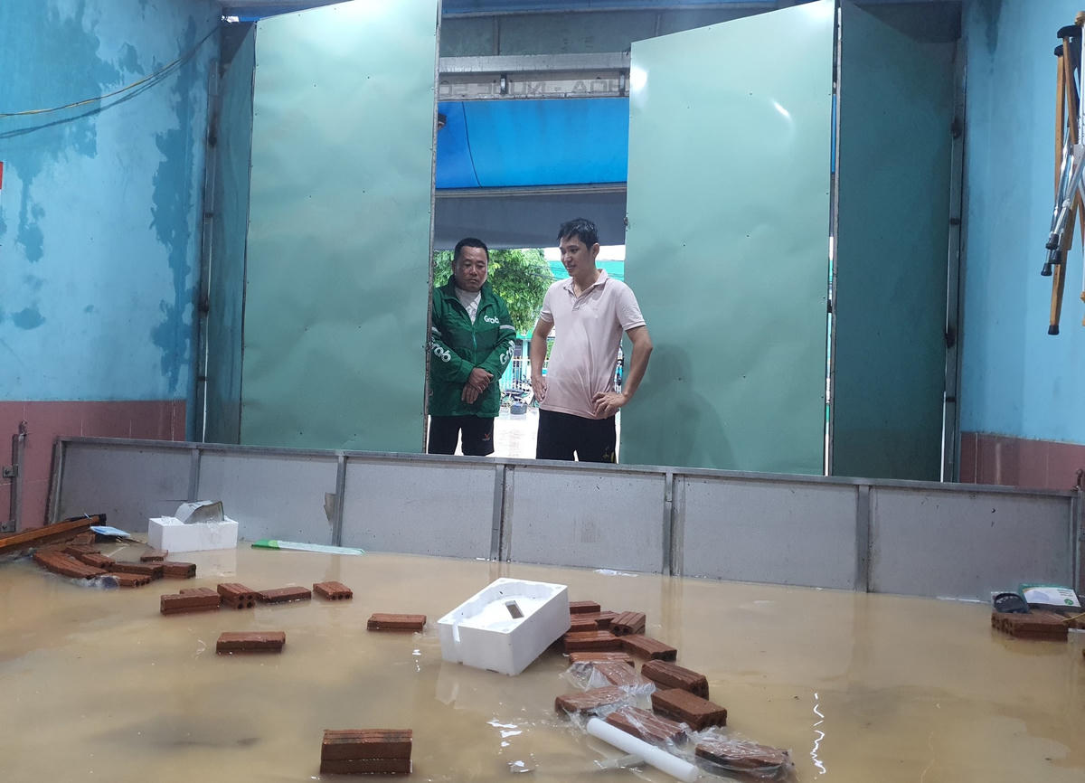 Anh Viễn bất lực nhìn nước tràn vào nhà.