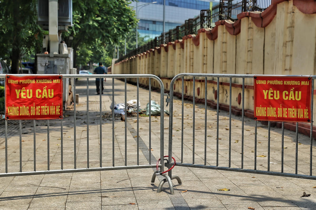 Vỉa hè khu vực ngã 3 Hoàng Văn Thái - Lê Trọng Tấn được lắp rào chắn và tấm biển "yêu cầu không dừng, đỗ xe trên vỉa hè".