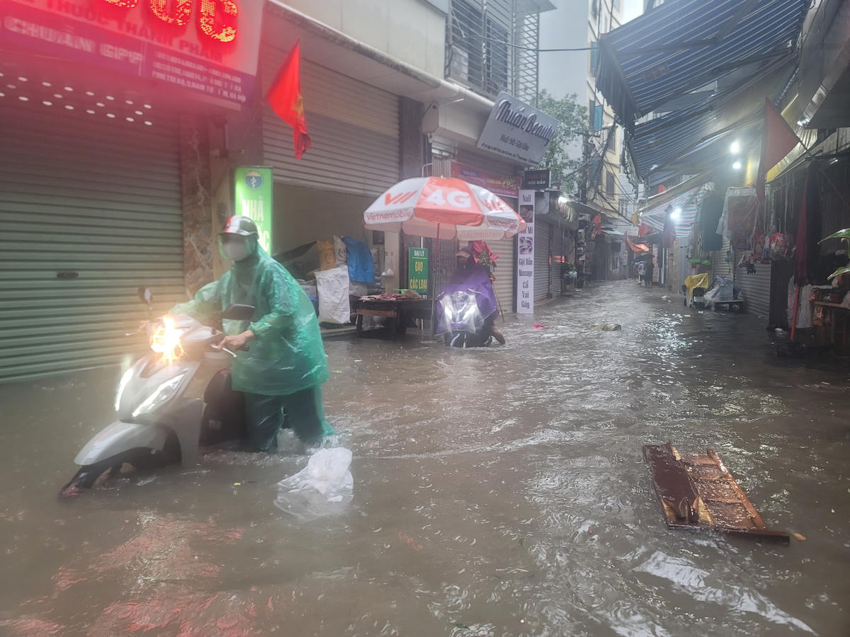 Hà Nội nhiều khu vực ngập trắng đường, người dân vất vả dắt xe, lội nước