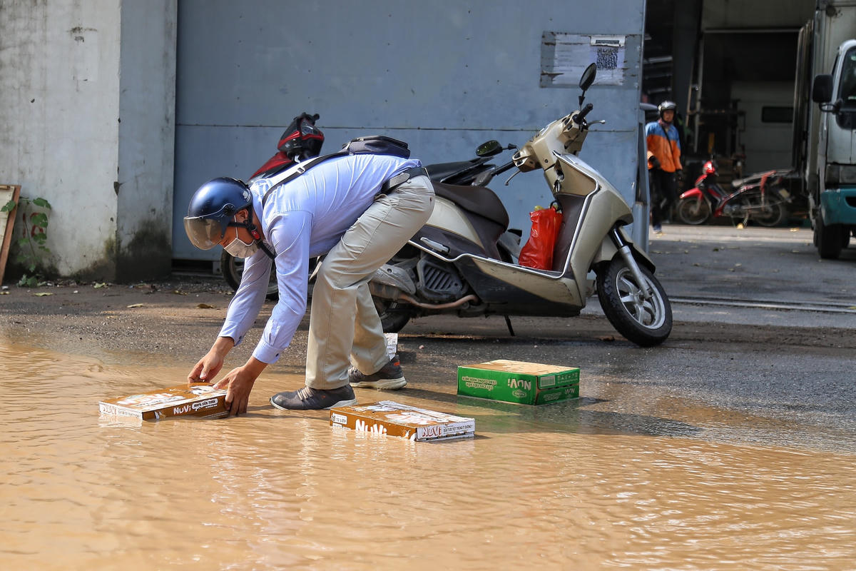 Người dân làm rơi đồ sau khi đi trúng vào ổ gà.