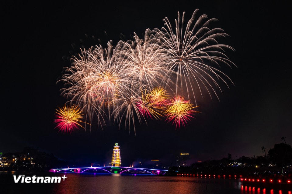 Hồ công viên Văn Lang ở trung tâm thành phố Việt Trì với cầu đi bộ trở nên huyền ảo trong màn bắn pháo hoa đêm trước Giỗ tổ Hùng Vương mùng 10/3 Âm lịch. (Ảnh: Hoài Nam/Vietnam+)