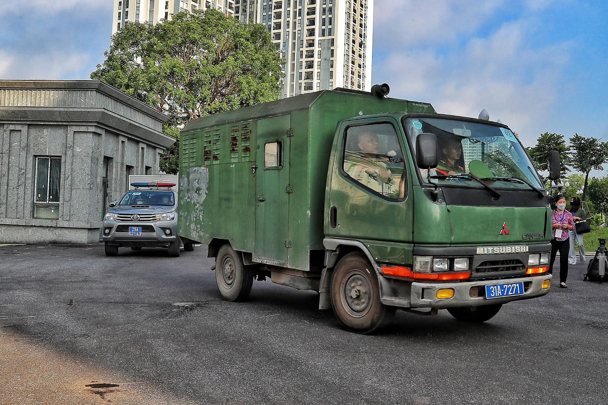 Hơn 7 giờ sáng ngày 11/7, 54 bị cáo trong đại án "chuyến bay giải cứu" bị lực lượng cảnh sát hỗ trợ tư pháp dẫn giải đến tòa. Sau khi bước xuống từ xe chuyên dụng, các bị cáo nhanh chóng được đưa vào phòng xét xử. Bên ngoài, lực lượng an ninh siết chặt. Những người tham gia tố tụng, bao gồm luật sư, phải qua cửa an ninh với sự kiểm soát nghiêm ngặt từ các cán bộ công an.