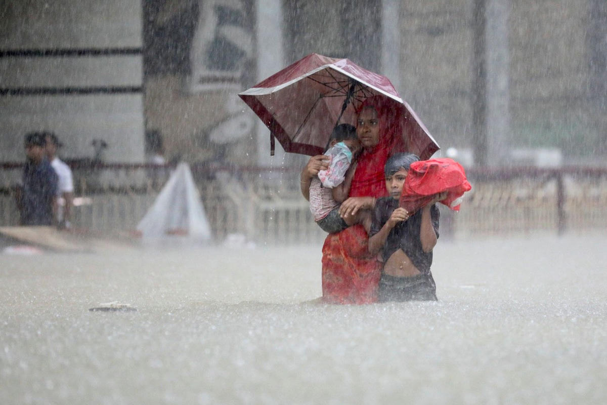 Mọi người lội qua dòng nước khi tìm nơi trú ẩn trong trận lũ lụt ở Sylhet, Bangladesh. Ảnh: Reuters.