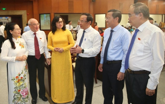 Lãnh đạo TP HCM trao đổi với đại biểu HĐND thành phố tại kỳ họp. Nguồn: NLĐ.