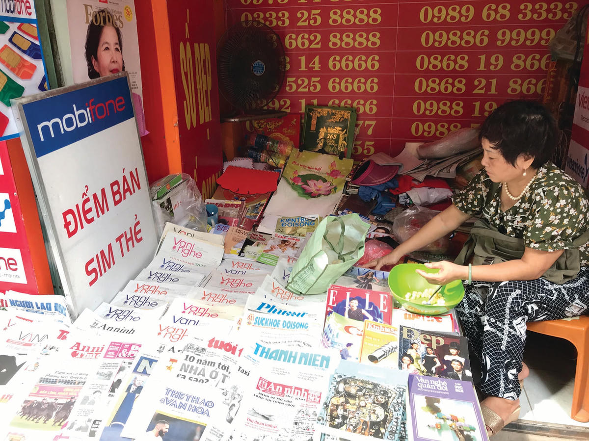 Sạp báo ở số 1 Hàng Trống cố bám trụ nơi “tấc đất tấc vàng”. Bên cạnh bán báo, các sạp báo còn thường bán sim, thẻ điện thoại và một số đầu sách để có thêm nguồn thu.  