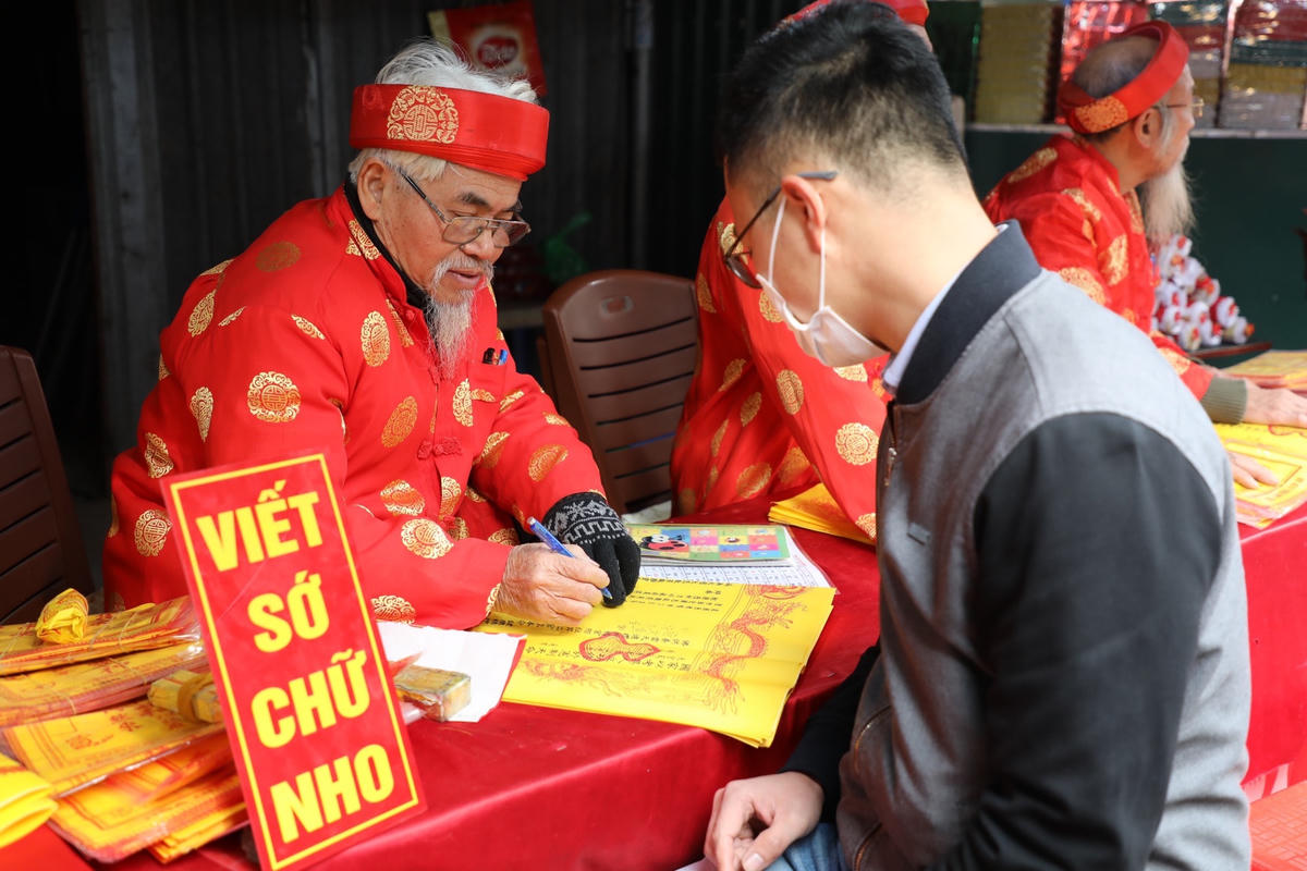 Người dân viết sớ trước khi vào phủ Tây Hồ để làm lễ.