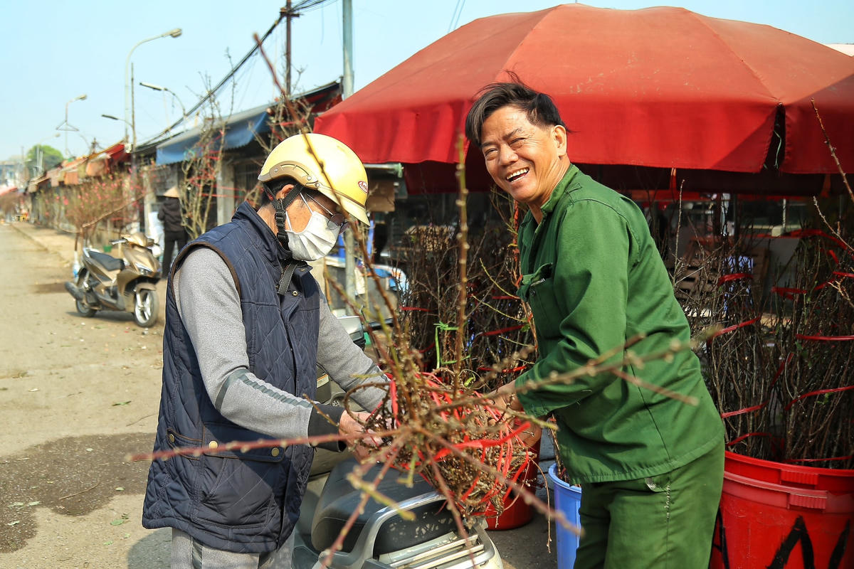 Hàng dài những cành hoa đào được bày bán tại chợ Quảng Bá đã đưa không khí Tết đến gần hơn.