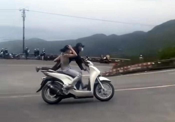 Đôi nam nữ điều khiển xe SH "làm xiếc" trên đèo Hải Vân. Ảnh cắt từ clip.