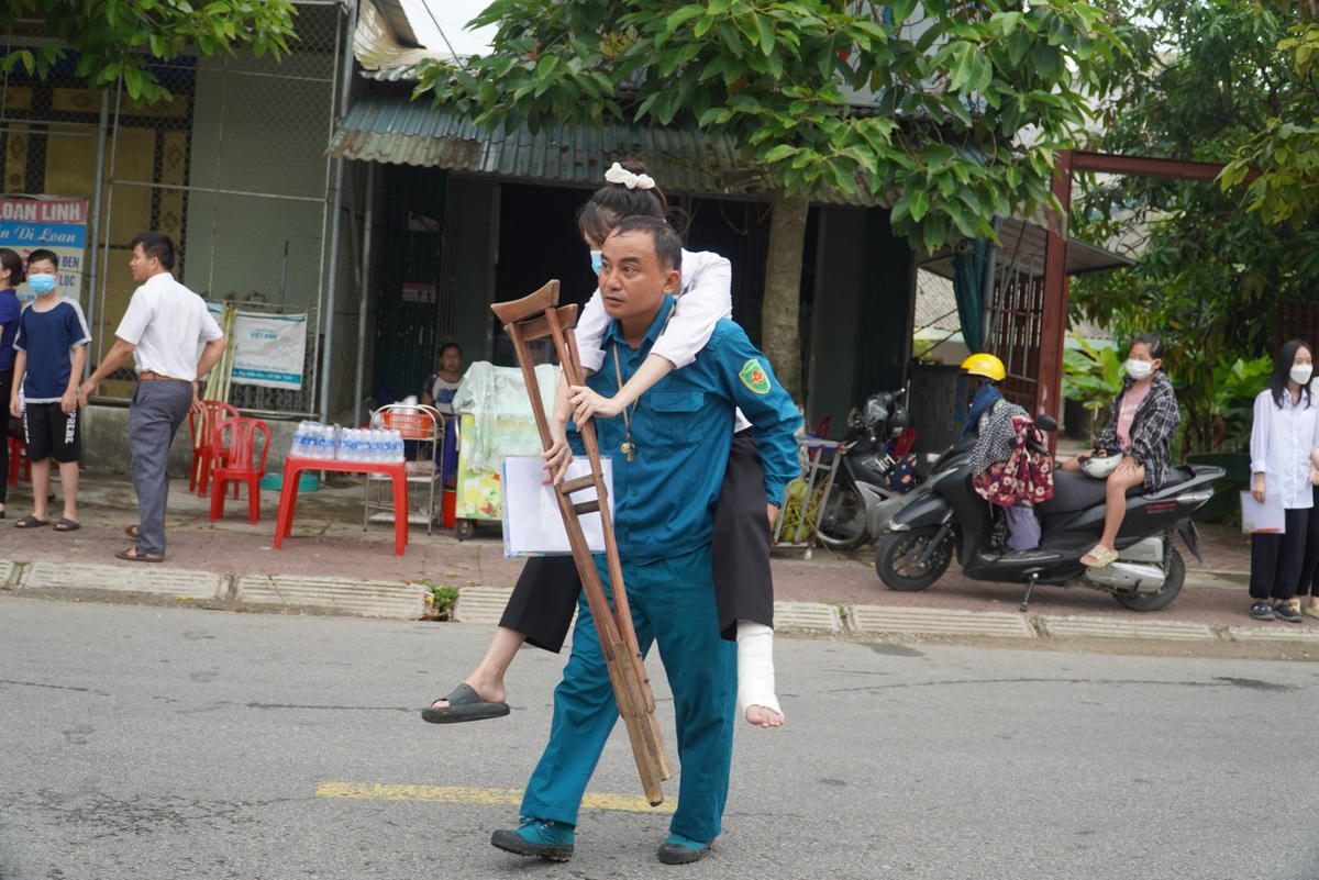 Con gãy chân đang phải bó bột, bố cõng con đến điểm thi.