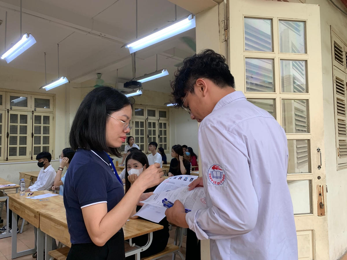 Cán bộ coi thi kiểm tra thông tin thí sinh trước khi vào phòng thi.